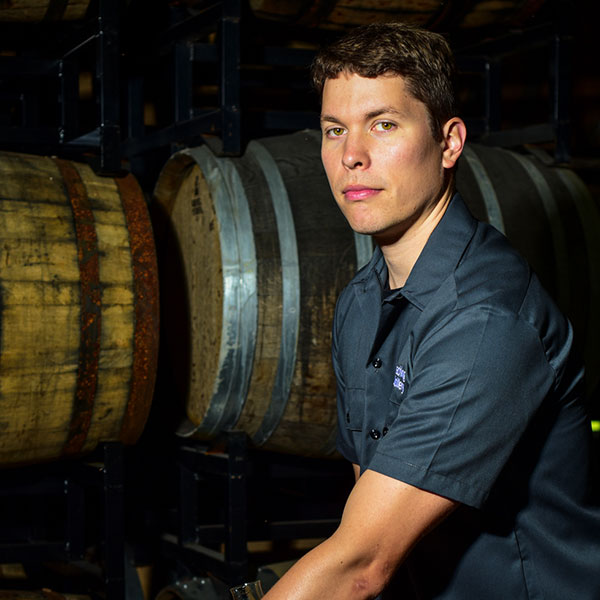 Distiller in front of casks